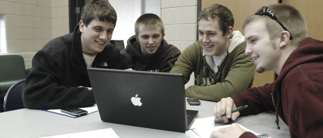 Four boys using a computer