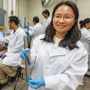 Jia Liu, foreground, associate professor of civil and environmental engineering, works with students in her lab at SIU.