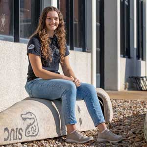 Morgan Klover, a senior in civil engineering from Decatur, Illinois, sits on one of the concrete canoes made by students at Southern Illinois University Carbondale.