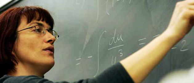 Woman solving equation on chalkboard